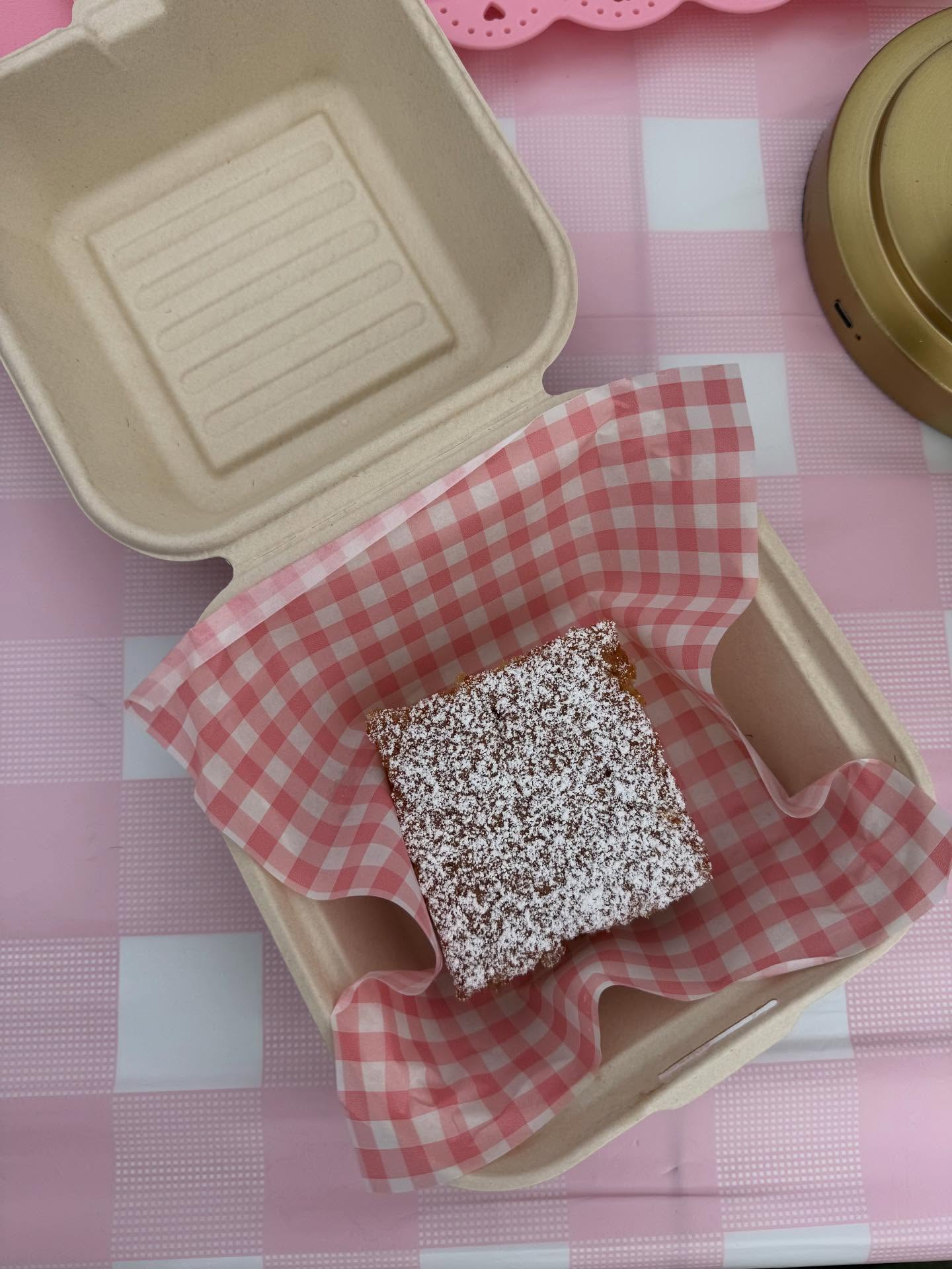 A slice of olive oil cake in a takeout box